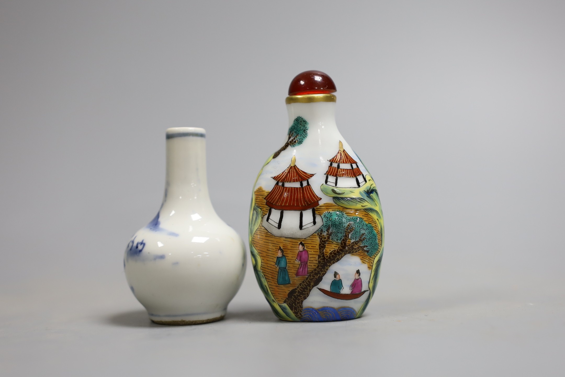 Two Chinese snuff bottles, to include a blue and white c.1900 bottle, and a famille rose bottle with stopper, largest 8.5cm long, (2)